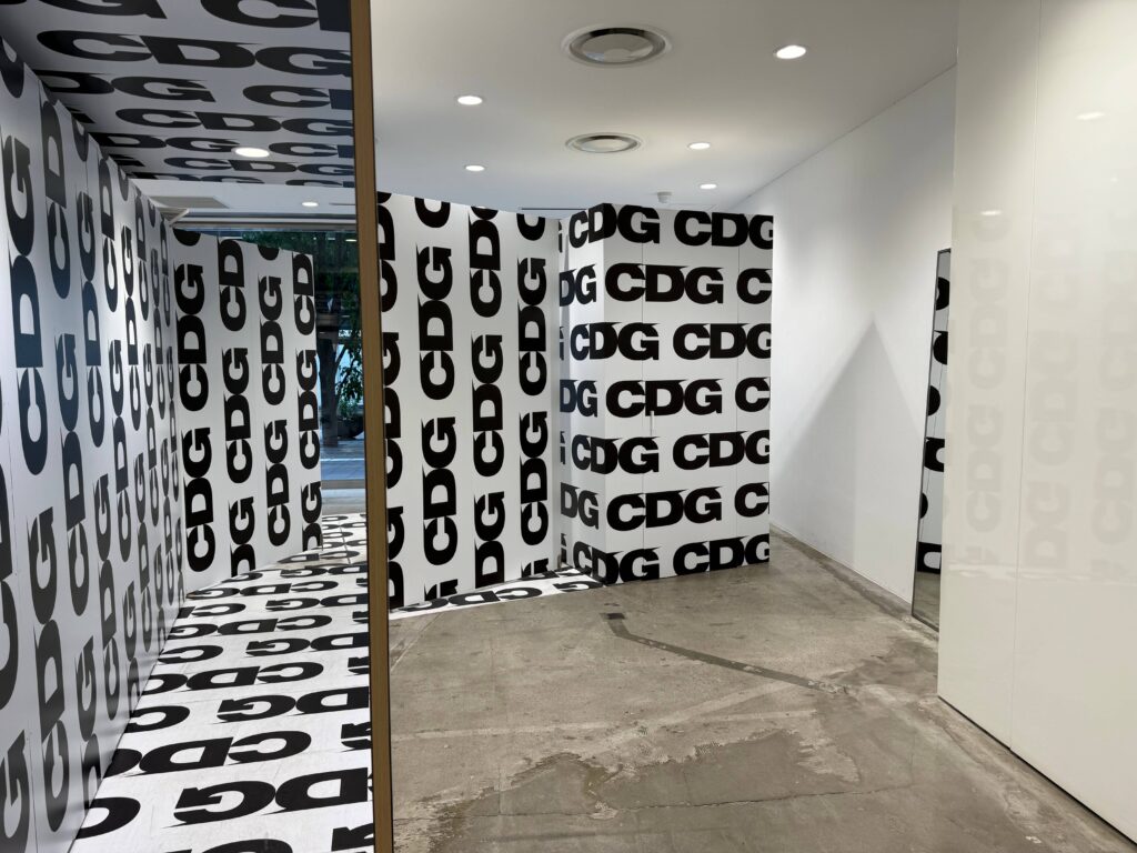 CDG store aisle and fitting room space covered in CDG logos