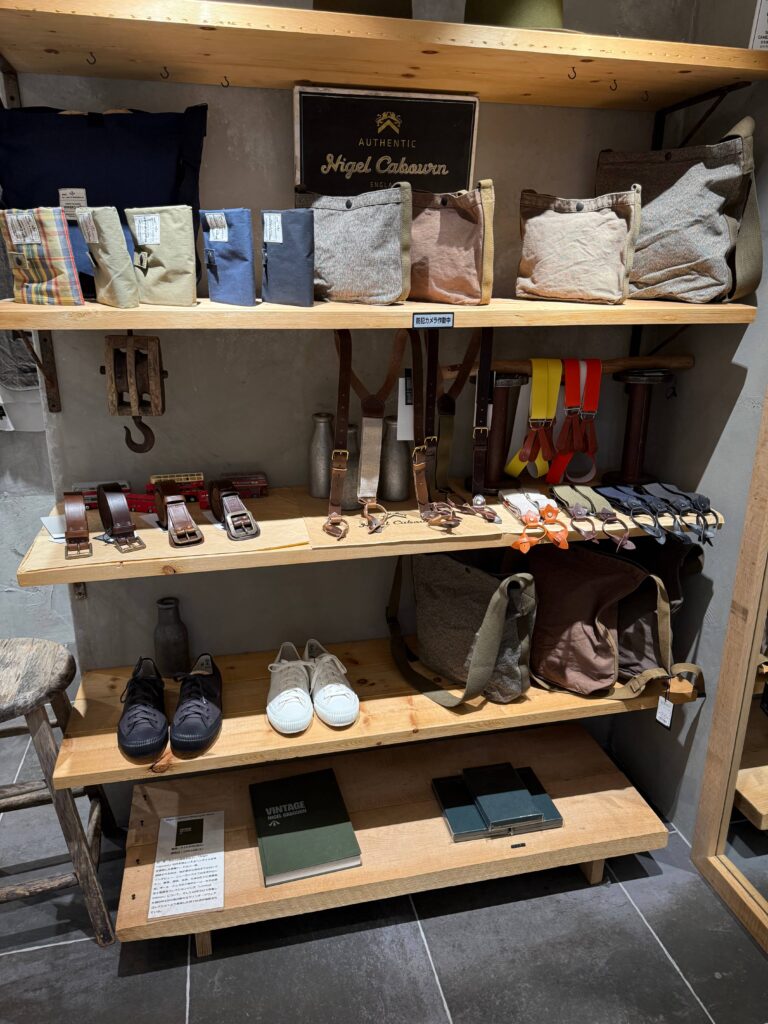 Leather belts, bags, and other small goods displayed at a Nigel Cabourn store