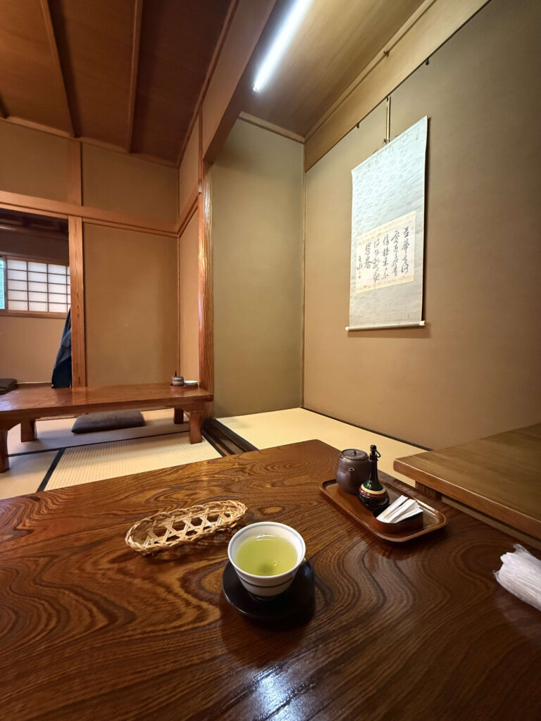 A traditional Japanese tatami room on the second floor, with a hanging scroll in the tokonoma alcove, shoji screens, and tatami mats, creating a serene atmosphere.