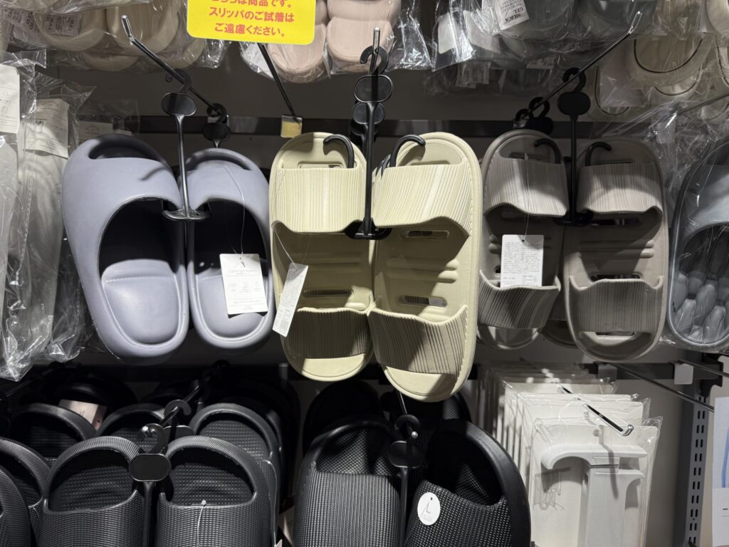 床に並べられた、前後の区別がないカラフルなサンダル群。ピンク、黄色、緑、青、紫など様々な色がある。