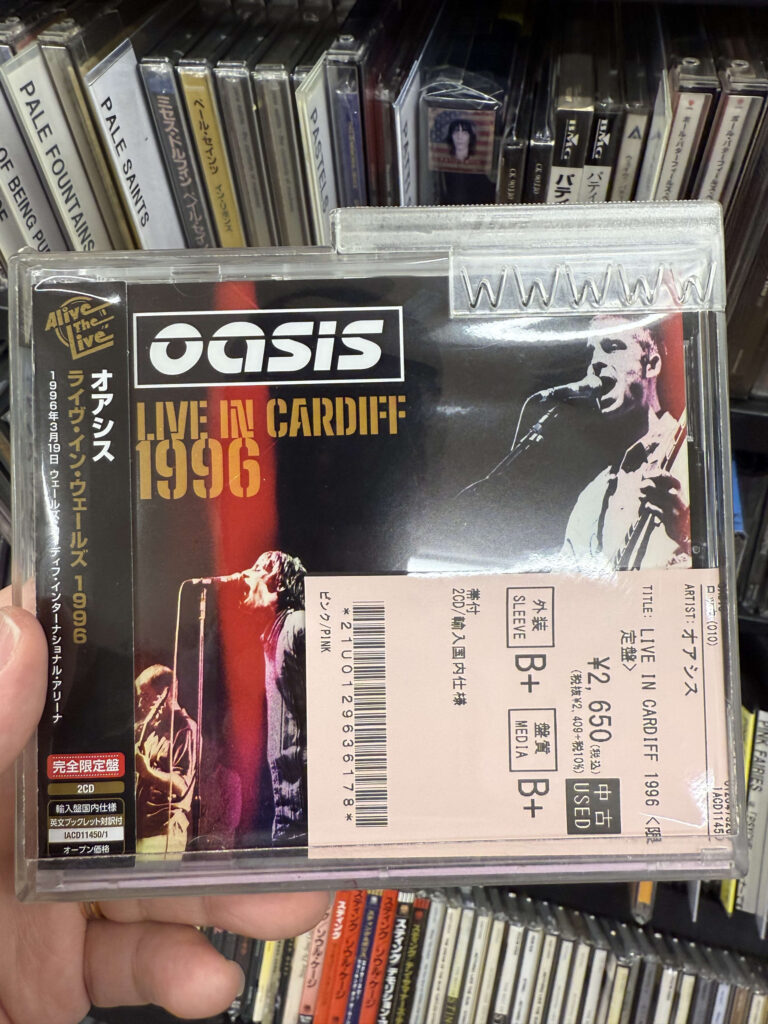 Oasis 1996 Cardiff concert live album cover image.