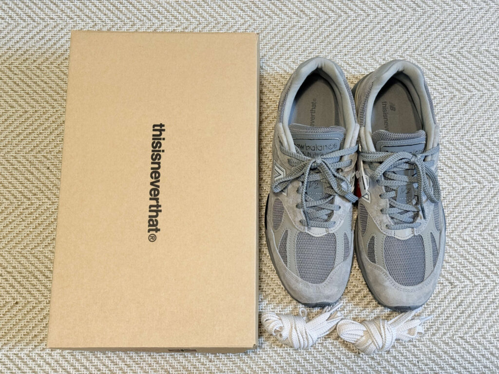 thisisneverthat と New Balance のコラボスニーカー 991v2 と付属品を上から撮影した写真。