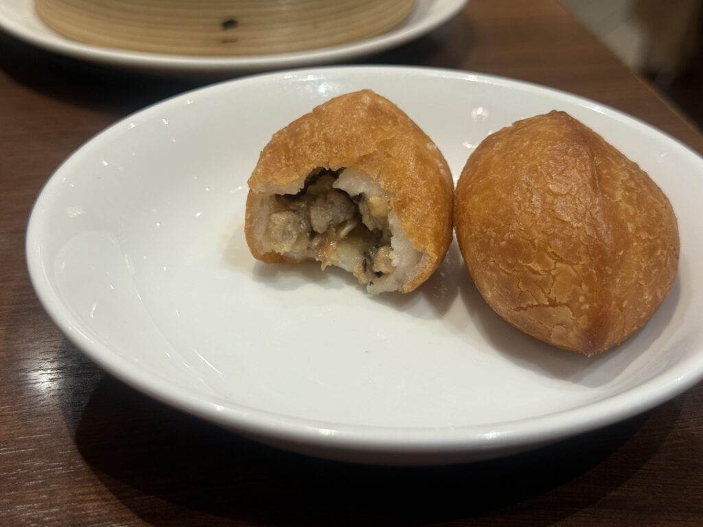 A photo showing the inside of a Gomoku Age Mochi (deep-fried rice cake with five kinds of ingredients), split in half. Colorful ingredients are visible.