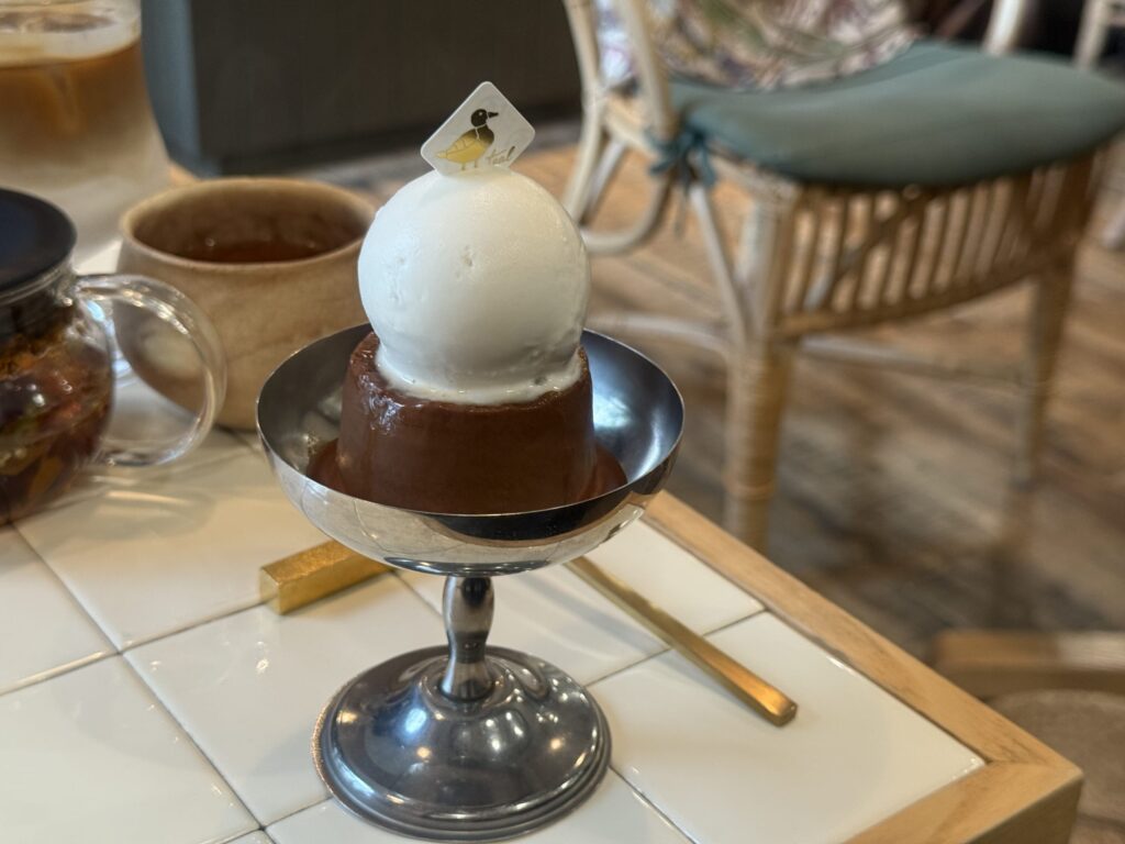 チョコレートプリンの上にミルクアイスクリームが乗っているデザートの写真。