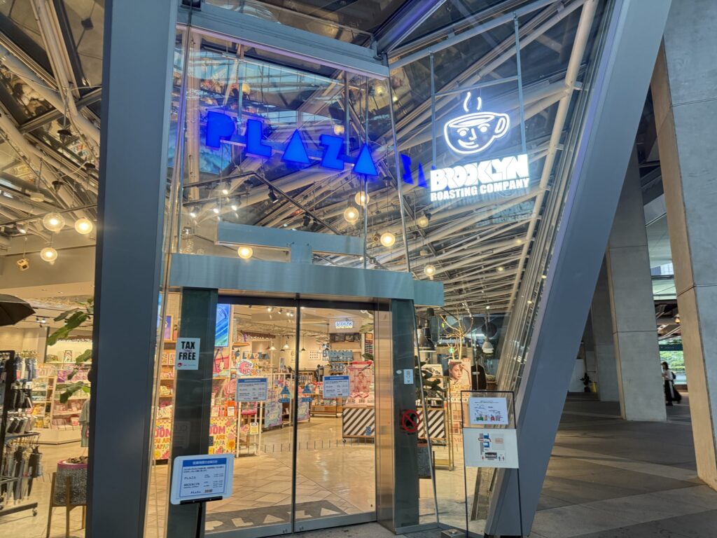 建物の間に並ぶ店舗群とPLAZAの看板、おしゃれなデザインの看板が目を引く街並み