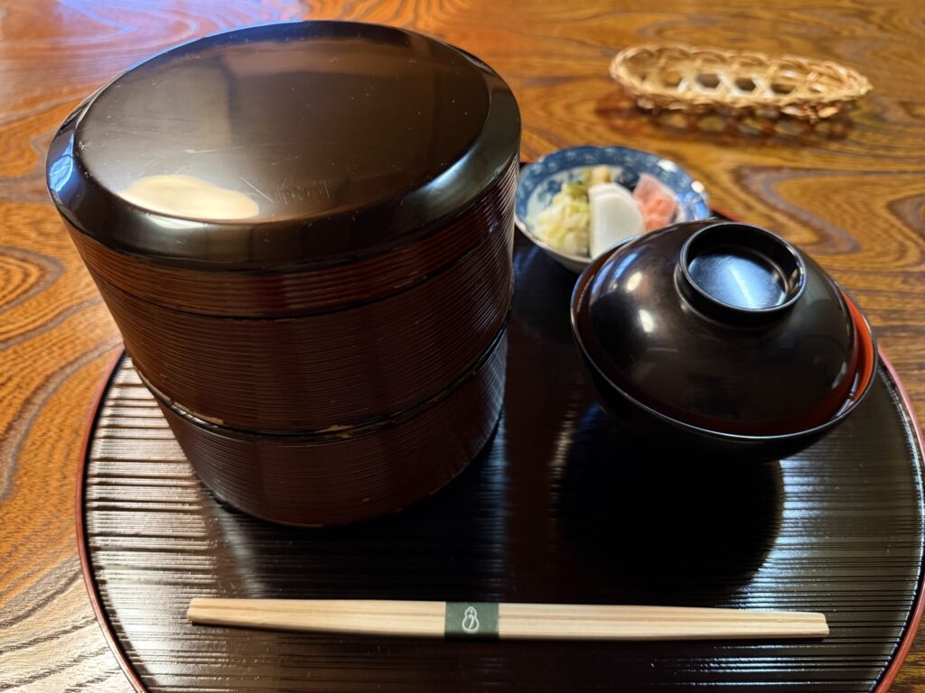 二段重ねの重箱に入ったうな重。上の段に鰻の蒲焼、下の段にご飯が盛られている。
