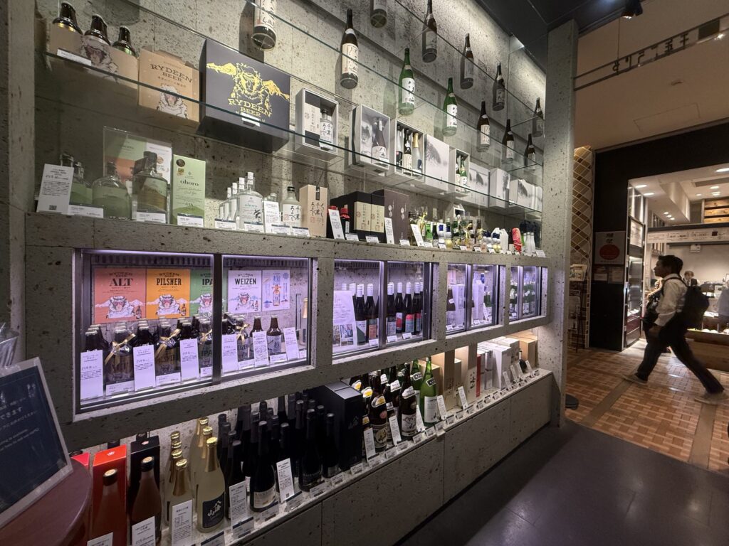 Various types of Hakkaisan sake bottles neatly arranged on shelves, viewed from an alternative angle.