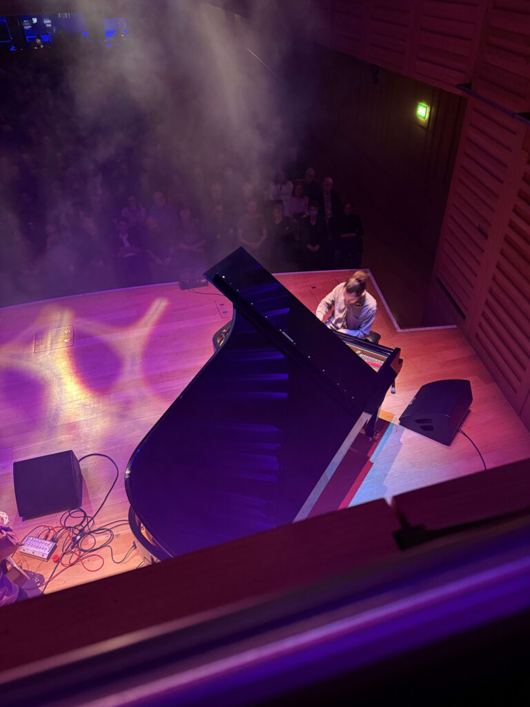 An artist performing a solo, illuminated by stage lights.