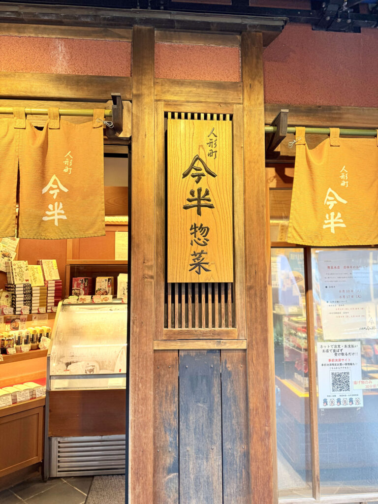 人形町今半の木製看板、黒地に白い毛筆風の文字で店名が書かれているクローズアップ写真