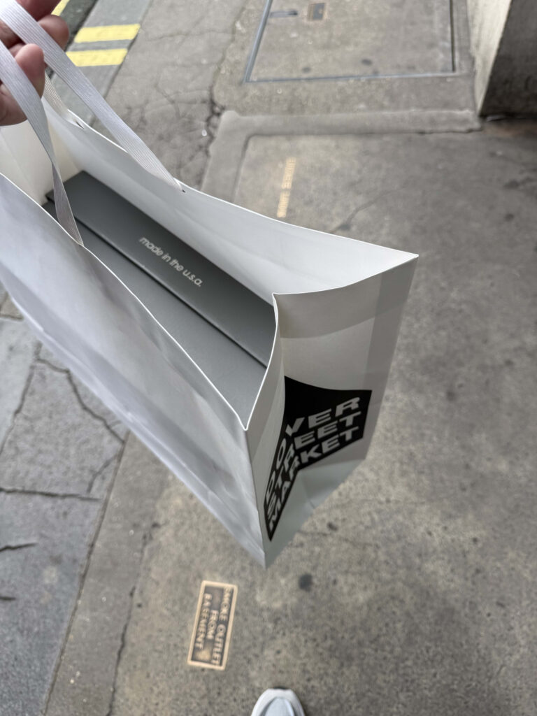 Grey-based New Balance 998 WTAPS collaboration sneakers placed on top of their shoebox.
