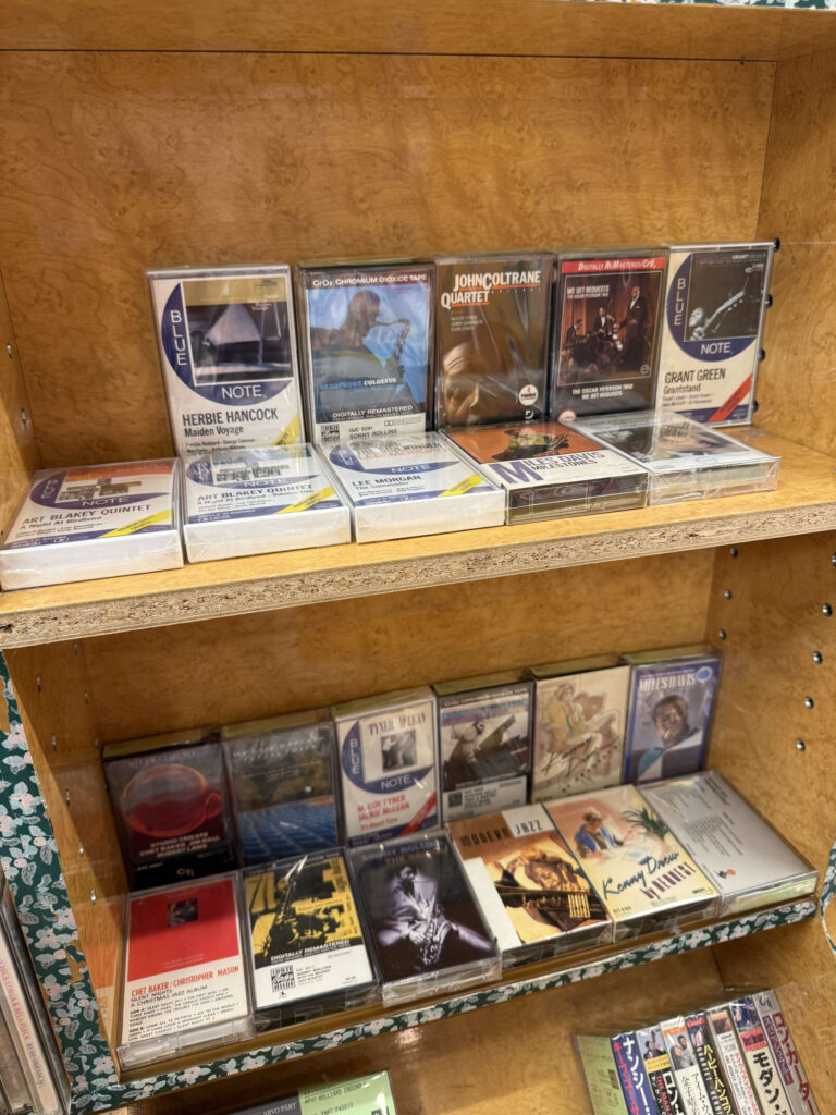 棚に並べられた中古カセットテープ。手前に「CASSETTE TAPE」と書かれたポップがある。