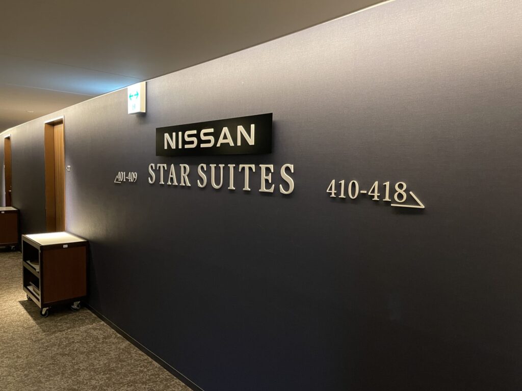 NISSAN STAR SUITESと書かれた看板がある、高級感のある廊下。
