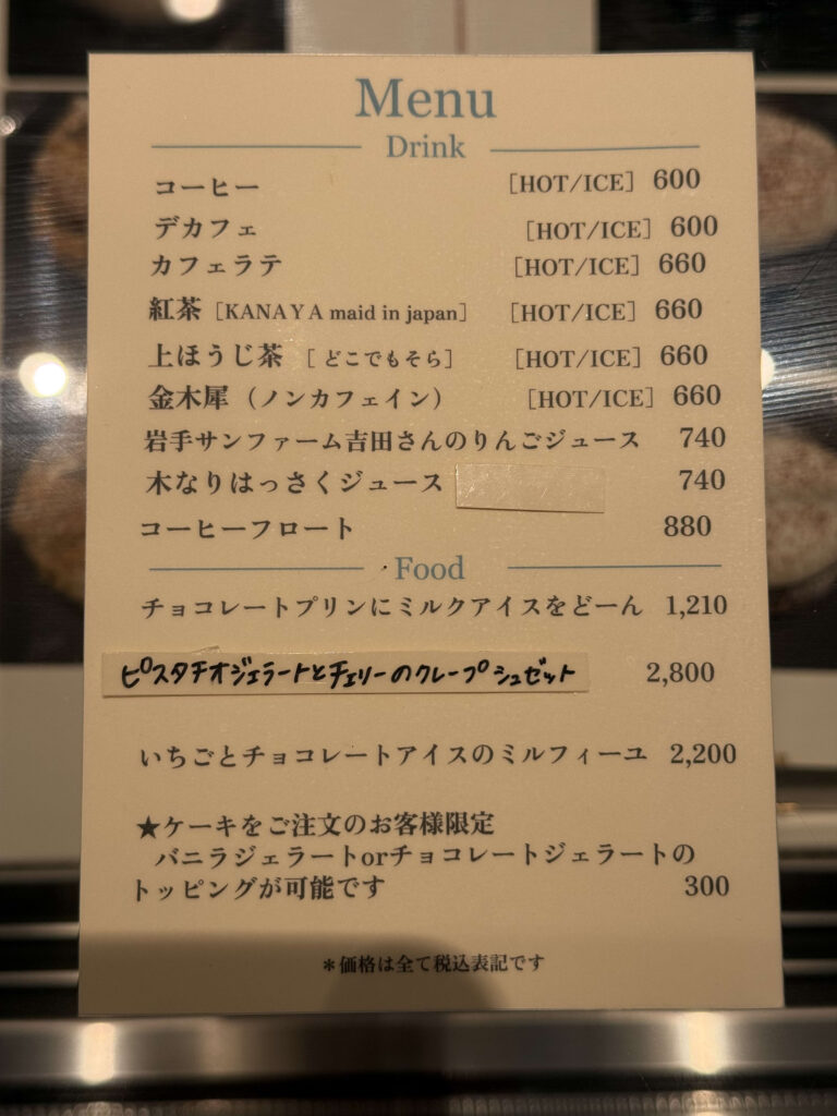 木製テーブルに置かれたカフェの手書き風イートインメニュー