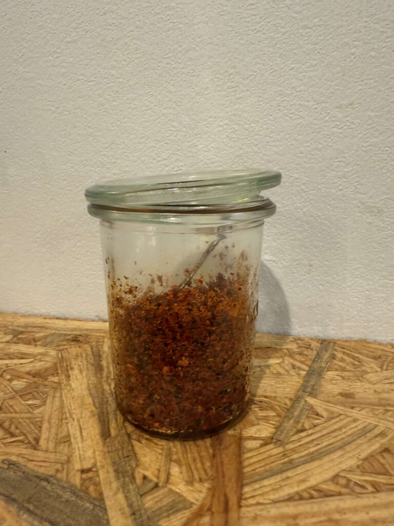Red chili spice on a spoon, for adding flavor to ramen.
