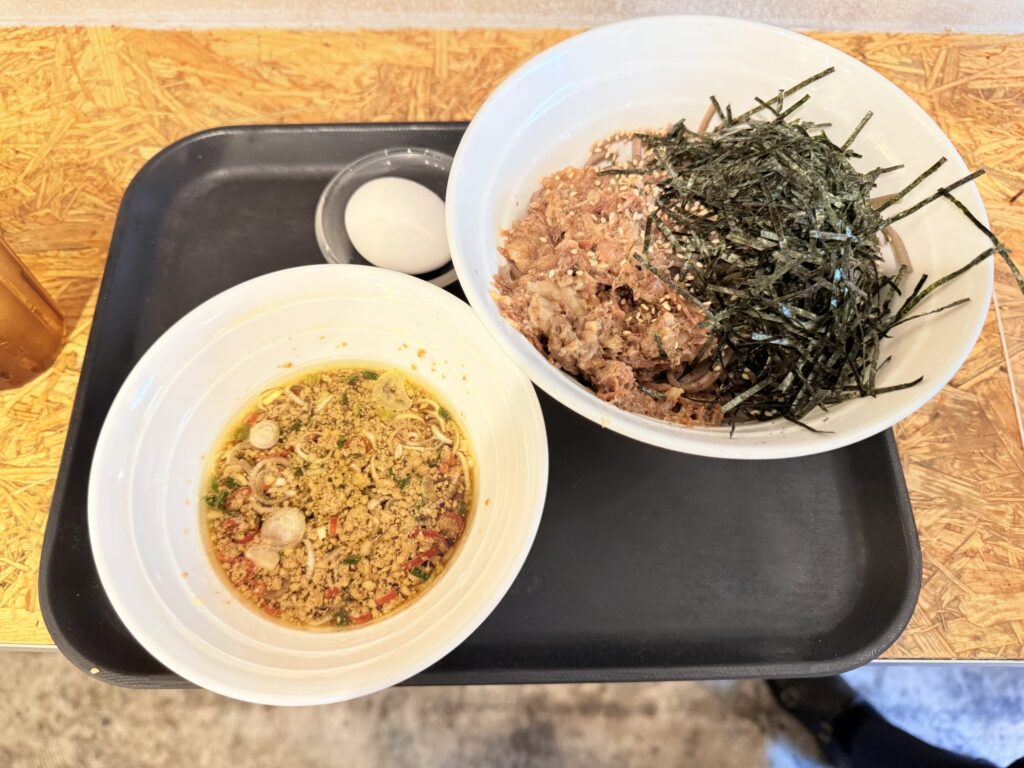 湯気を立てる温かい牛すじそば、ネギが添えられている