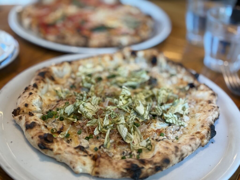 Close-up shot of an Umami Pizza, topped with savory mackerel.