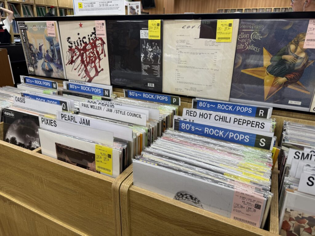 Numerous record jackets displayed on shelves in a used record store