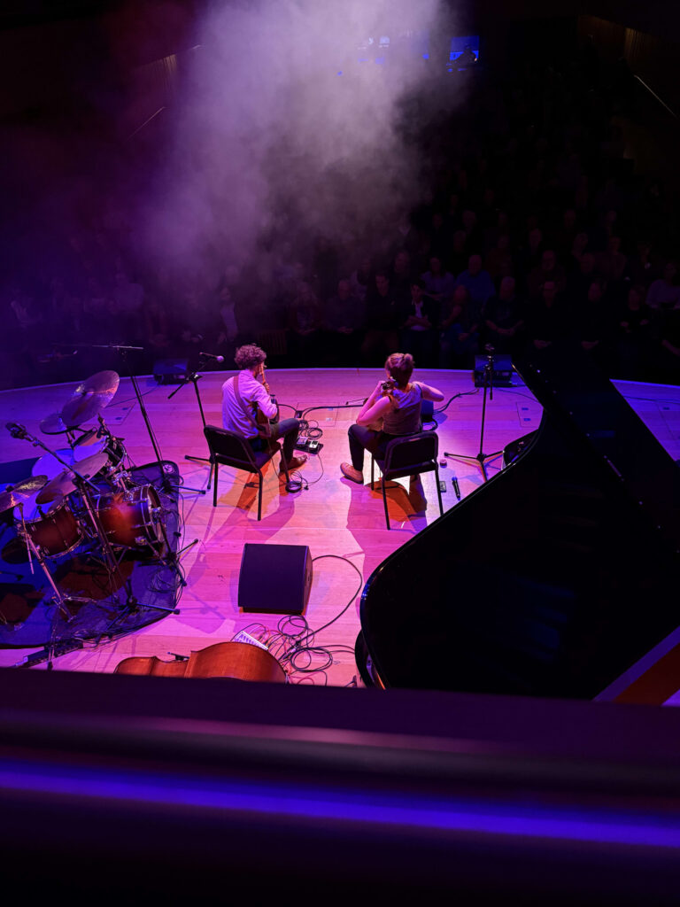 The opening band performing on stage, with the audience excited.