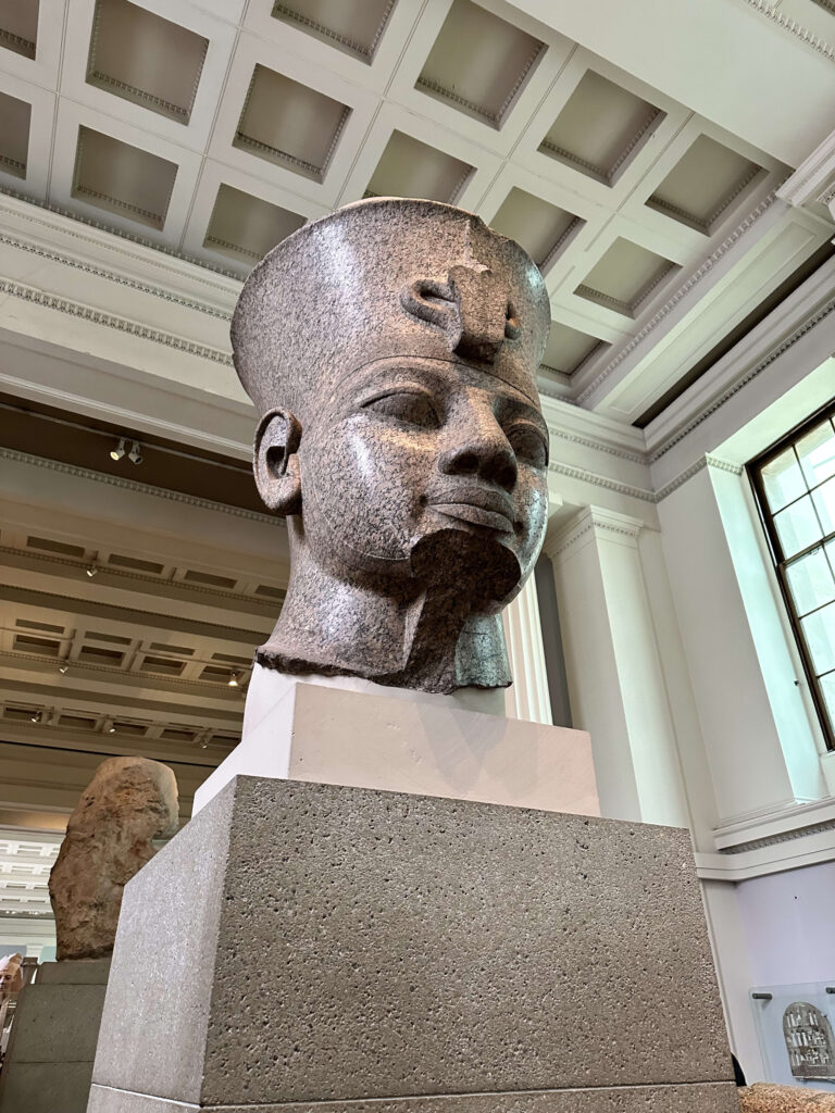 青空の下に立つ、古代エジプトのファラオ、アメンホテプ3世の巨大な石の坐像。