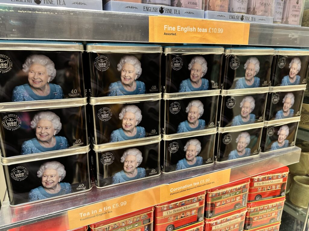 A package of Twinings' commemorative tea for Queen Elizabeth II on a shelf. The design is primarily red and white and features a portrait of the Queen.