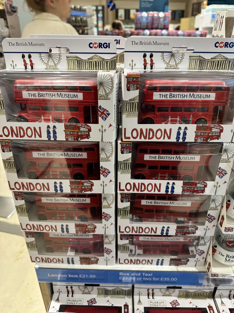 木製の棚の上に置かれた、赤いロンドンバスのミニチュア模型。