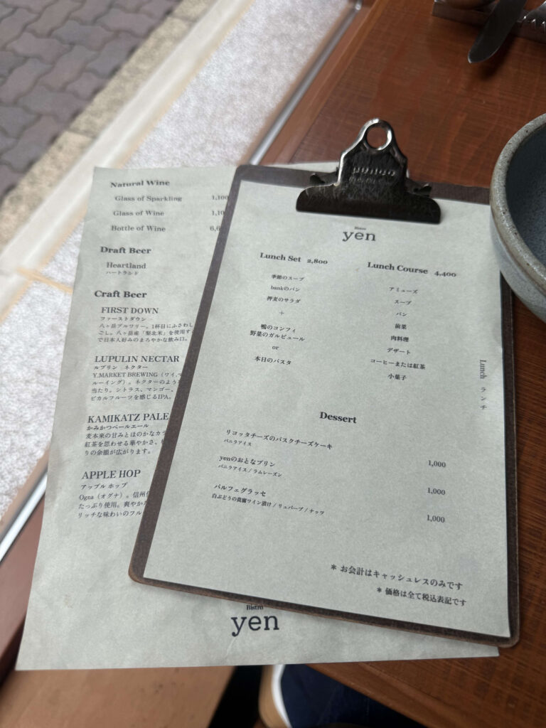 The menu for Bistro Yen resting on a dark wooden table under warm, soft lighting.