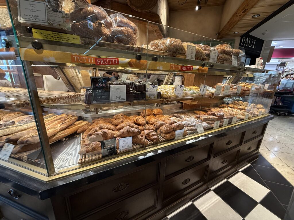 Pastries such as canelés and croissants arranged in a display case at the bakery Paul.