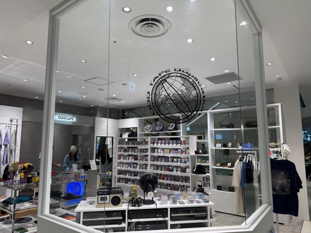 カセットテープ専門店「Oddtape」の白を基調としたモダンな外観。大きな窓からは店内に並ぶカセットテープが見える。