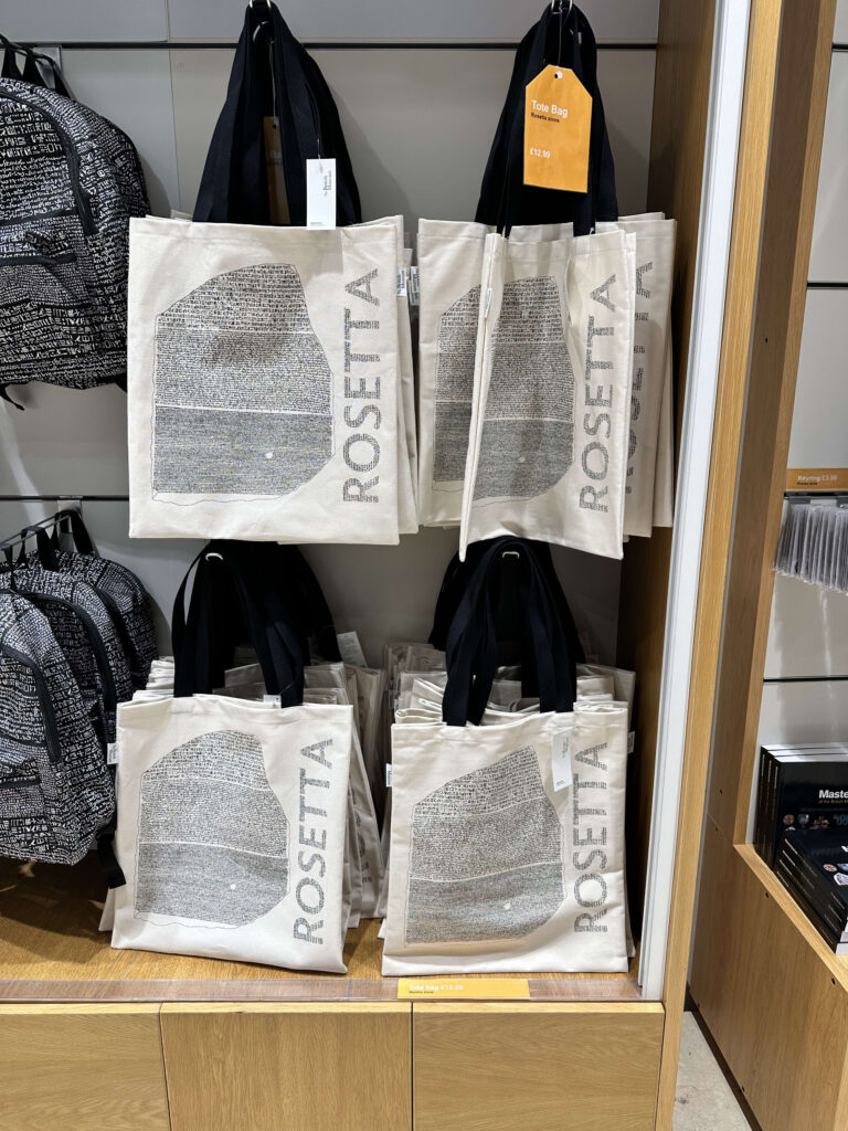A person holding a white tote bag with a Rosetta Stone design.