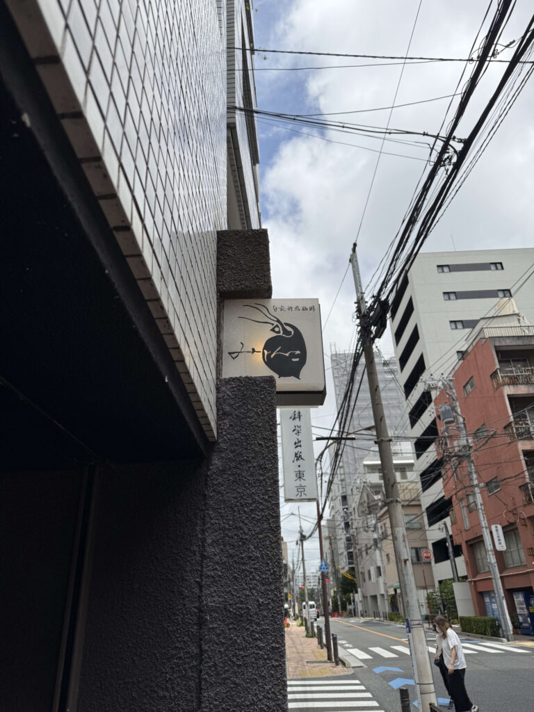 青空を背景に立つ、巨大なみじんこの形をした白い看板。