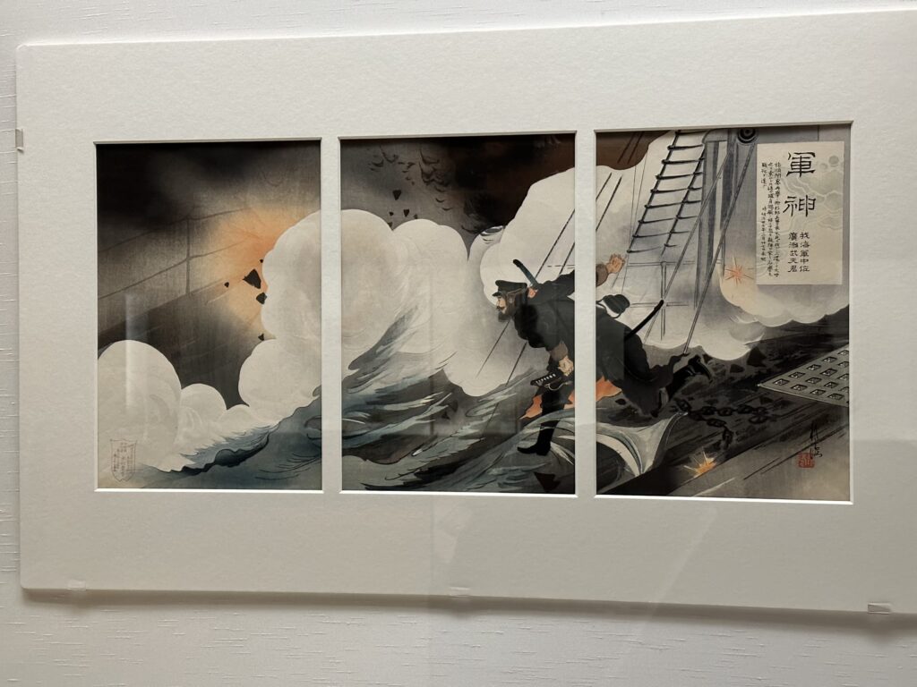 A nishiki-e (woodblock print) from Tsukioka Kogyo's 'War Legend' series. It depicts a heroic scene of Commander Takeo Hirose in military uniform, attempting to rescue a subordinate by carrying him on his back amidst the smoke of an explosion.