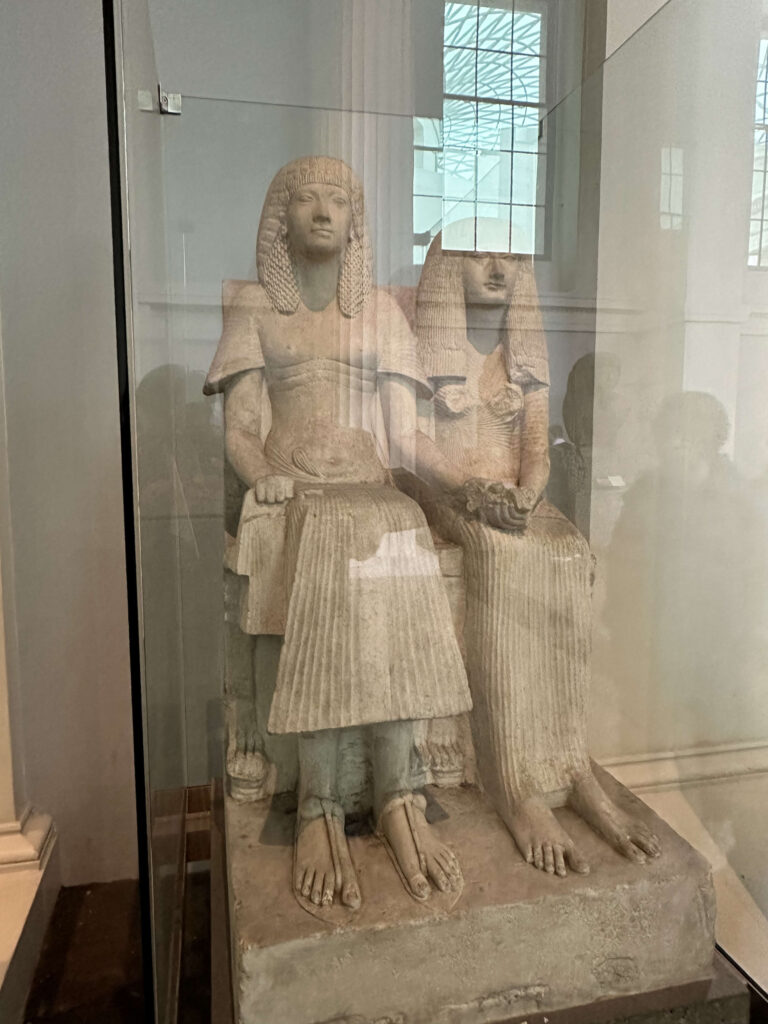 古代エジプトのホルエムヘブと妻アメニアの坐像。黒い石に彫られた二人が寄り添って座っている。