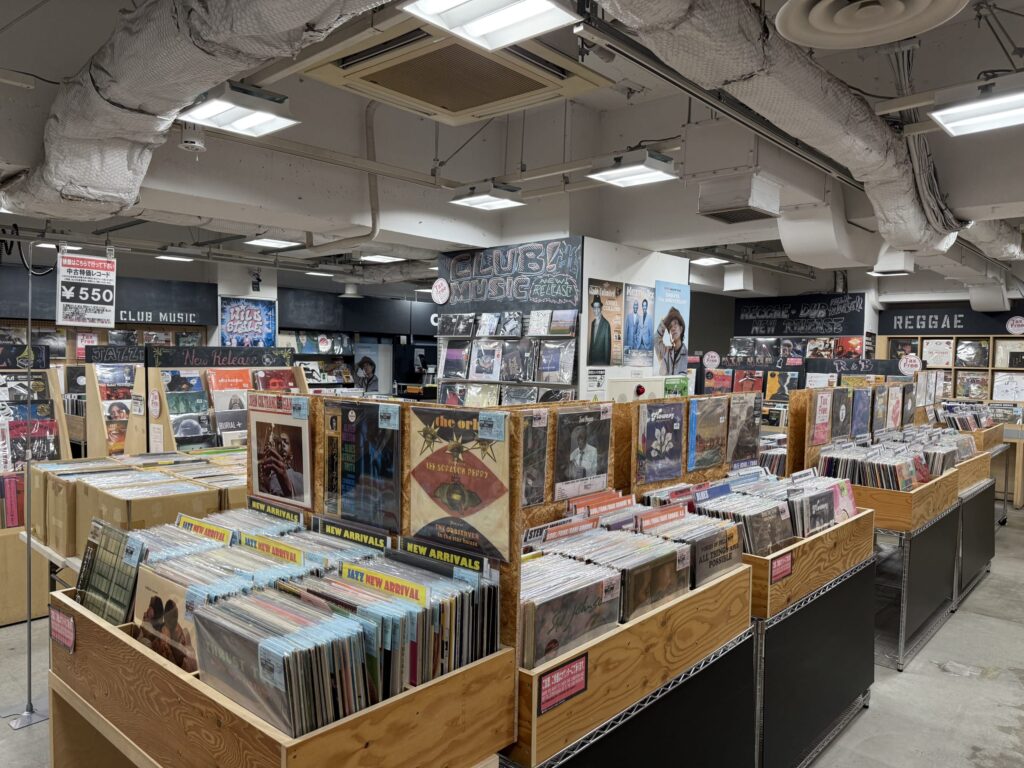 HMVのレコードショップ2階の店内。Hip-Hop、R&B、テクノのジャンルを示す看板の下に、アナログレコードやCDが陳列された棚が並んでいる。