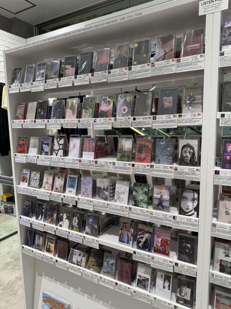 カセットテープ専門店「Oddtape」の店内。木製の棚に「ALTERNATIVE」と書かれた仕切りがあり、たくさんのカセットテープがぎっしりと陳列されている様子。