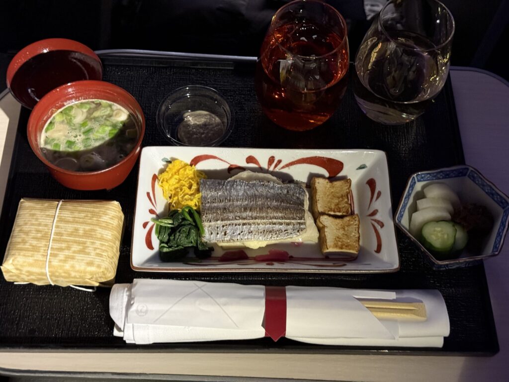 A Japanese set meal (teishoku) with cutlassfish on a wooden tray. It features the main grilled fish, a bowl of rice, miso soup, and several small side dishes.