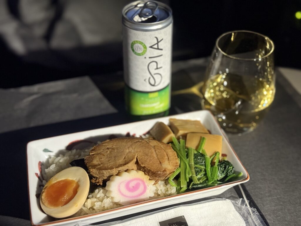 ご飯の上に厚切りチャーシュー、極太メンマ、味付け玉子、ネギが乗ったラー飯丼のクローズアップ。