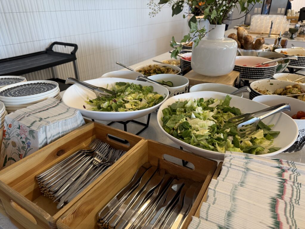 A buffet table featuring fresh green salads and various dishes.
