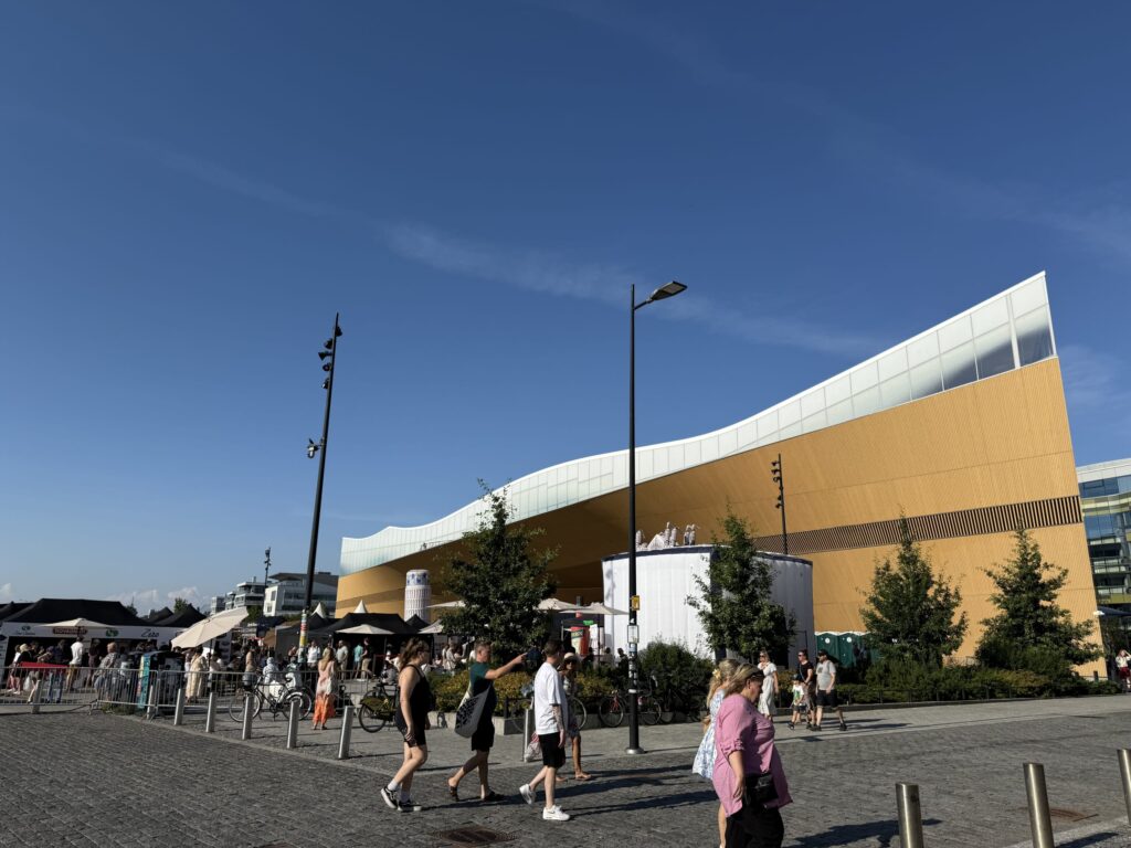 晴れた日のヘルシンキ中央図書館Oodi。手前の広場ではイベントが開催されており、多くの人々で賑わっている様子。