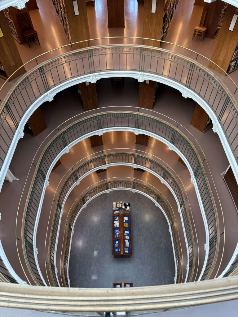 図書館の吹き抜けを上層階から見下ろした写真。楕円形の回廊が何層にも重なり、螺旋状の構造を作り出している。