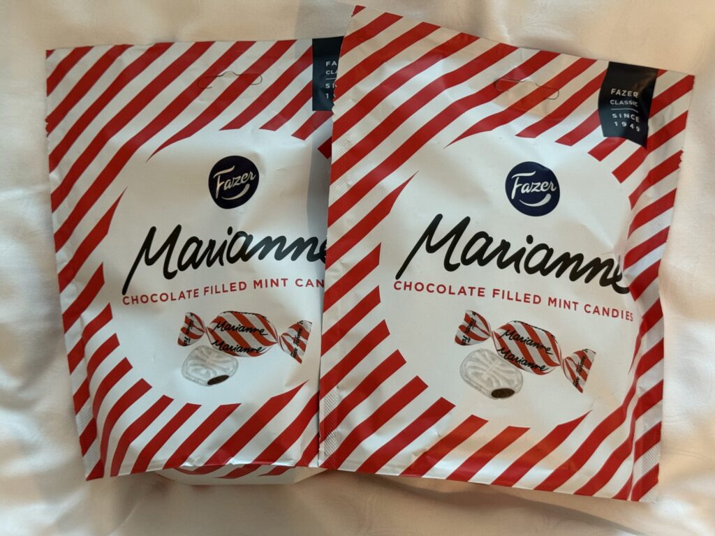 白い布の上に置かれた、ファッツェル(Fazer)社のマリアンヌ(Marianne)チョコレート入りミントキャンディー2袋。パッケージは赤と白のストライプ柄。
