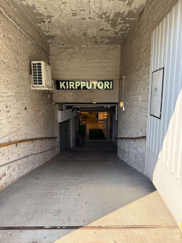 ヘルシンキにある古着屋（KIRPPUTORI）の、レンガの壁に囲まれた地下へと続く坂道の入り口。