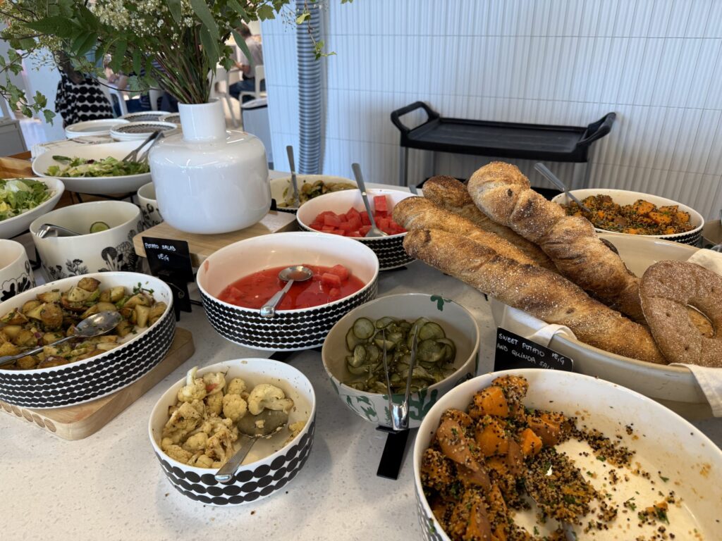 A buffet-style salad bar with various salads, deli dishes, and freshly baked bread.