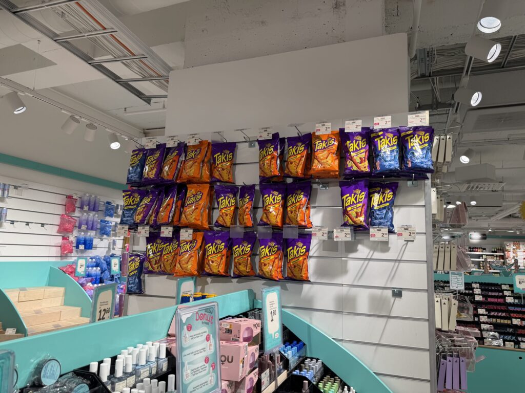店内の白い壁の陳列棚に、様々な種類のタキスチップスが何列にもわたって掛けられている様子。