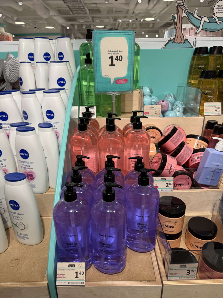 店の棚に、ニベアやピュアリビングなど様々なブランドのカラフルなシャワージェルやボディケア商品が価格表示とともに陳列されている。
