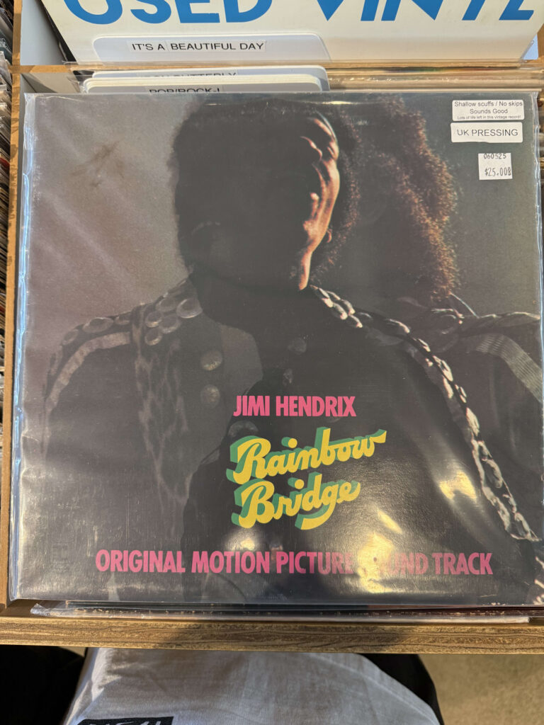 Jimi Hendrix's album 'Rainbow Bridge' in a record store crate. A sticker on the cover indicates the price and that it is a UK pressing.