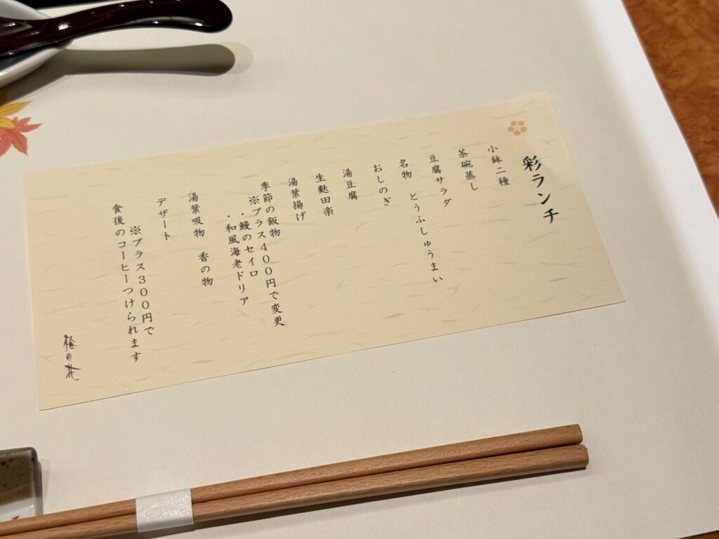 和食のテーブルに置かれた「彩ランチ」のお品書き。手前には木製のお箸が添えられている。