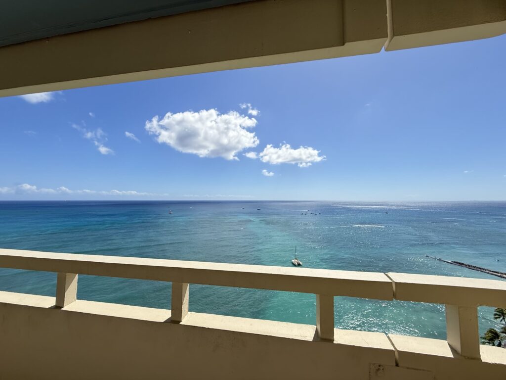 ラナイのバルコニーから望む、青い空とターコイズブルーの海。海には数隻のボートが浮かんでいる。