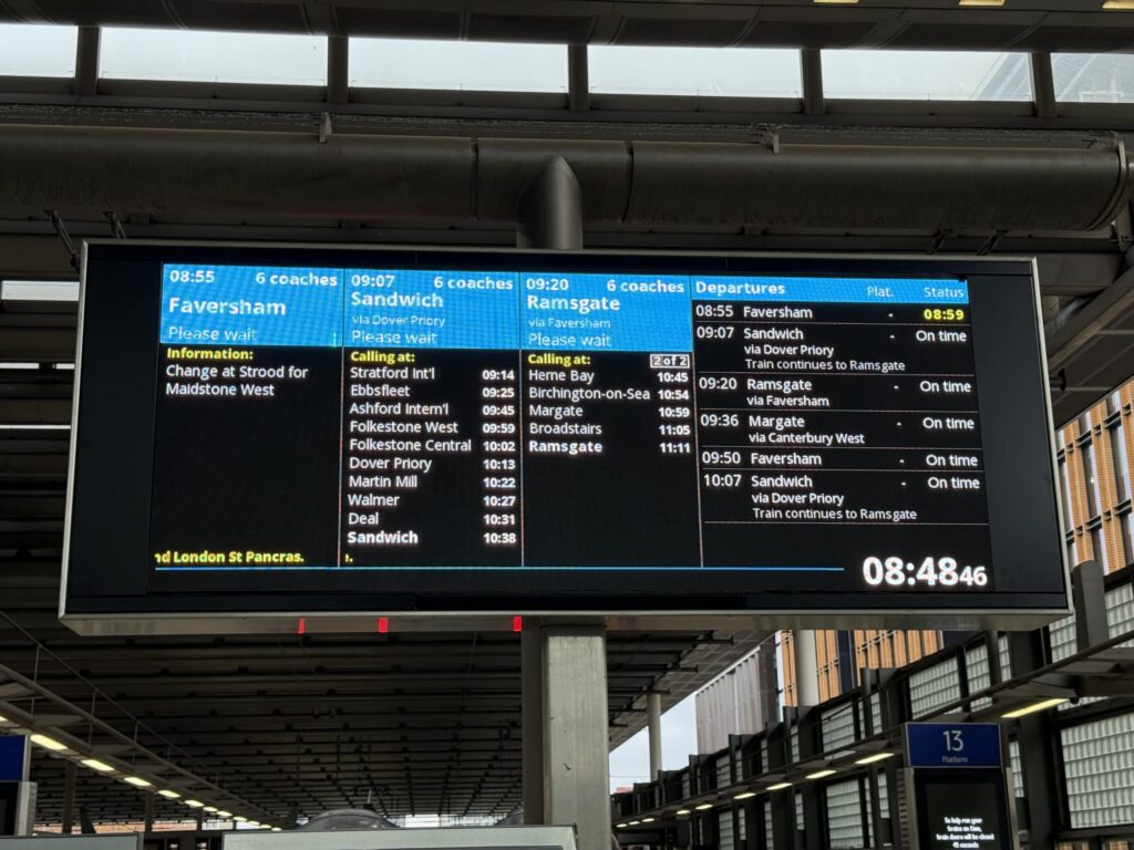 セント・パンクラス駅のプラットフォームに設置された、列車の出発情報を示す大きな電光掲示板。フェイバーシャム、サンドイッチ、ラムズゲート行きの情報が表示されている。