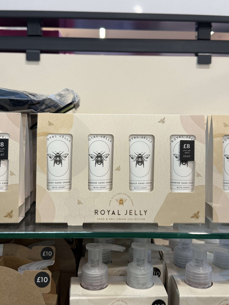 店舗の棚に陳列されたロイヤルゼリー・ハンド&ネイルクリームの4本セット。蜂のイラストが描かれたパッケージで価格は8ポンド。
