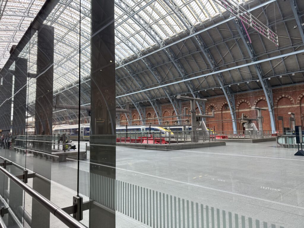ロンドンのセント・パンクラス駅のホームに停車中のユーロスター。ガラスの壁越しに、アーチ型の鉄骨とガラスの天井が見える。